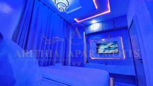 a blue room with a bed and a tv at Arithia Apartments in Mama