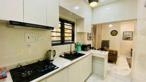 a kitchen with white cabinets and a stove top oven at Arithia Apartments in Mama