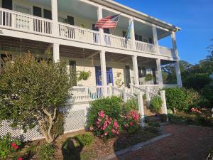 ein großes weißes Haus mit einer amerikanischen Flagge darauf in der Unterkunft Gloucester House with Sea View in Gloucester + 10 Fotos