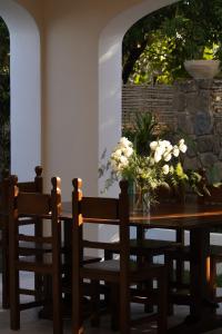a dining room table with chairs and flowers on it at Casa Olivi in Ventotene