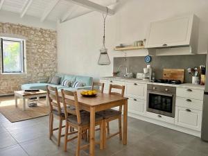 a kitchen and living room with a table and a couch at Maison Bleu Katomeri in Katomérion +13 photos