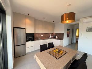 a kitchen with a table with chairs and a refrigerator at Luxury Apartment The Best in Cavtat