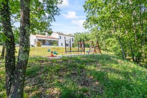 ein Spielplatz in einem Garten mit einem Haus in der Unterkunft Vila Prisunca with jacuzzi & swimming pool in Pazin