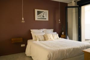 a bedroom with a large bed with white sheets at La maison du Potier in Valras-Plage