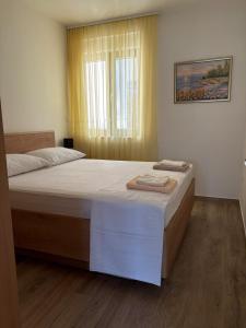 a bedroom with a bed with two towels on it at Luxury Apartment The Best in Cavtat