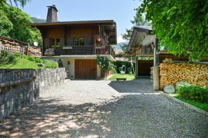 a house with a stone fence and a driveway at Chambre D'hôtes La Télécabine in La Balme-de-Thuy
