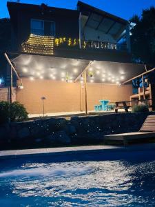 ein Haus mit Swimmingpool bei Nacht mit Lichtern in der Unterkunft ClCabañas in Huerta Grande + 13 Fotos
