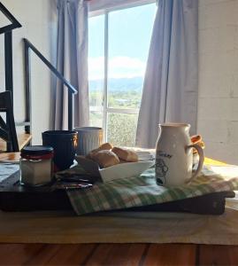 ein Tisch mit einer Kaffeetasse und einem Teller Brot in der Unterkunft ClCabañas in Huerta Grande