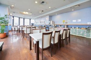 a restaurant with a white table and chairs at Hotel Select Inn Aomori in Aomori