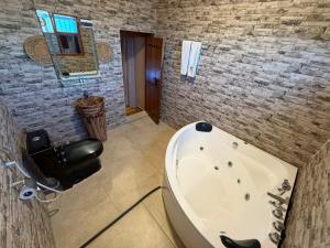 a bathroom with a white tub and a stone wall at Aldar Inn - نزل الدار in Nizwa
