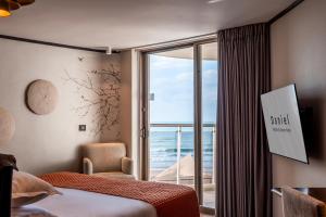 ein Schlafzimmer mit einem großen Fenster und Meerblick in der Unterkunft Daniel Herzliya Hotel in Herzlia