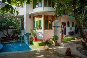 a woman standing in front of a house with a pool at Bungalows Puerta de Sol in Brisas de Zicatela