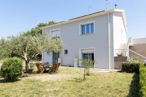 a white house with a table and chairs in the yard at Italian Experience-Art&Sea House in Fano