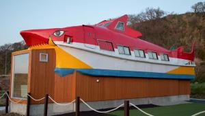 a large boat sitting on top of a building at Harbor base SHARK in Sado