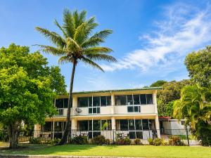 a palm tree in front of a building at Pippies Beachhouse Backpackers in Rainbow Beach