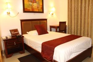 una camera con letto, tavolo e sedia di Hotel Residence Flamani a Lomé