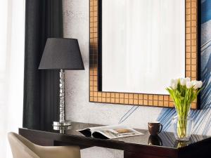 a desk with a lamp and a vase of white flowers at Mövenpick Hotel Jumeirah Lakes Towers Dubai in Dubai +112 photos