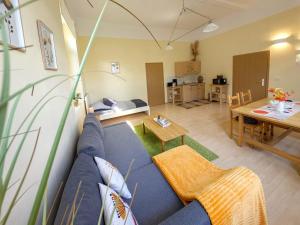 a living room with a blue couch and a table at Ferienwohnung Barbarossa - Holly in Rottleben +24 photos