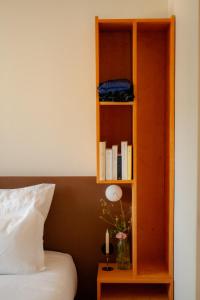 a book shelf next to a bed in a room at Coureilles Appartements et Suites in La Rochelle