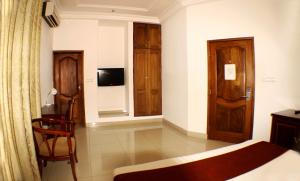 a bedroom with a bed and a chair in a room at Hotel Residence Flamani in Lomé