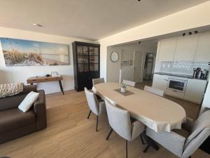 a living room with a table and a couch at Orion NorthSea Suite in Blankenberge