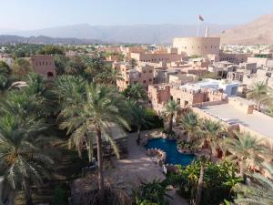 an aerial view of a city with palm trees and buildings at Aldar Inn - نزل الدار in Nizwa