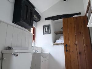 a bathroom with a sink and a toilet and a door at Brewhouse Cottage 18th Century Cottage -Three Peaks Settle in Settle +24 photos