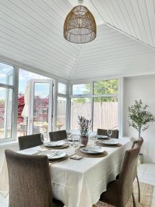 a dining room with a white table and chairs at Alder House Lytham in Lytham St Annes