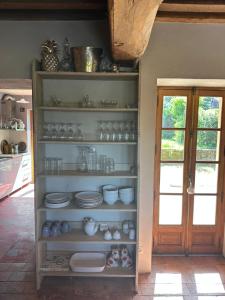 a shelf with plates and bowls on it in a kitchen at MAISON LA TRANQUILITÉ by Frans & Ricardo in Saint-Didier-sur-Arroux