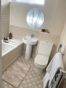 a bathroom with a toilet and a sink and a tub at Alder House Lytham in Lytham St Annes +36 photos