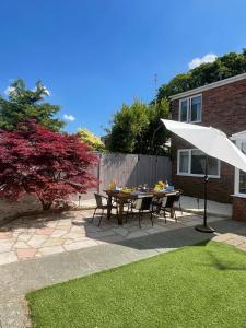 a patio with a table and an umbrella at Alder House Lytham in Lytham St Annes
