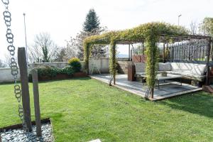 a pergola with a bench in a yard at Casa di Babii in Serle