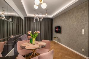a living room with pink chairs and a table with flowers at Apartament Bursztynowa Komnata 116 Stegna nad morzem in Stegna
