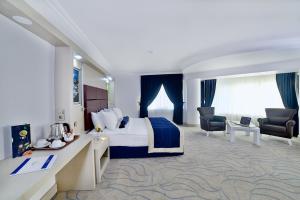 a hotel room with a bed and a desk and chairs at Elazığ Marathon Hotel in Elazığ