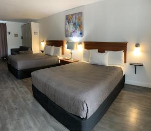 a hotel room with two beds and a couch at Complexe Hotelier Escoumins in Les Escoumins +54 photos