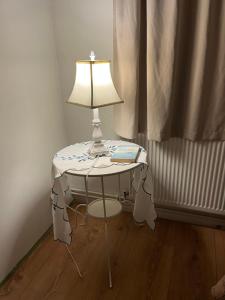 a table with a lamp and a book on it at Quarto single in Stykkishólmur