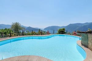a large swimming pool with mountains in the background at Agriturismo El Giardì in Marone