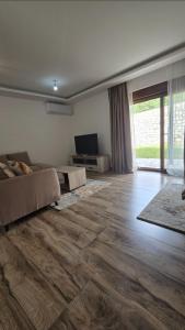 a living room with a couch and a television at Lux studio - Vrh Đevojka in Borje