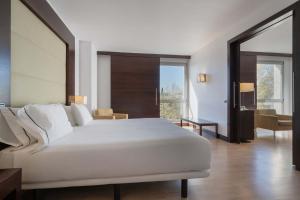 una camera da letto con un grande letto bianco e un soggiorno di Eurostars i-hotel Madrid a Pozuelo de Alarcón Altre 31 foto