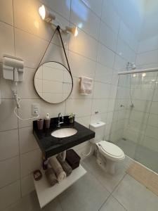 a bathroom with a sink and a toilet and a mirror at Self check-in Garagem Ar 13 min ABQM in Araçatuba