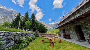 a garden with a table and a stone building at Kulla e Sadri Lukes in Theth +45 photos