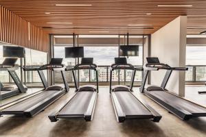 a gym with treadmills and a large window at Movinn Nine - Jardim Paulista in São Paulo +57 photos