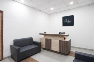 a waiting room with a chair and a podium at Hotel O Noida Sky Suites Sector 44 Near botanical metro in Badarpur