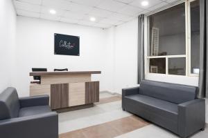 a waiting room with two chairs and a desk at Hotel O Noida Sky Suites Sector 44 Near botanical metro in Badarpur +22 photos