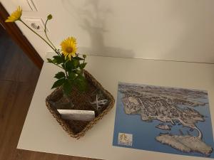a vase with a flower on a table next to a book at Quarto single in Stykkishólmur