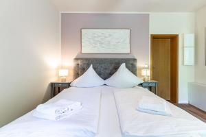 a bed with white sheets and towels on it at Strandleben - Galerie Nummer 13 in Ahrenshoop +28 photos