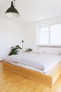 a bed in a white bedroom with a large window at Apartment 39 in Giengen an der Brenz
