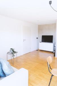 a living room with a white couch and a television at Apartment 39 in Giengen an der Brenz