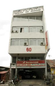 a tall white building with a sign on it at Sim cityStay in George Town