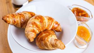 a white plate with croissants and orange jam on a table at Tava Motel Manitou Springs in Manitou Springs